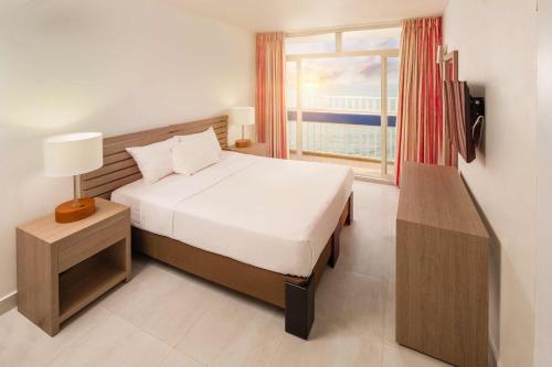 卡塔赫纳卡塔赫纳得可麦仑全包酒店的一间卧室设有一张床和一个大窗户