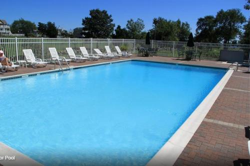 韦斯特利Winnapaug Inn的周围设有大型蓝色游泳池,配有躺椅