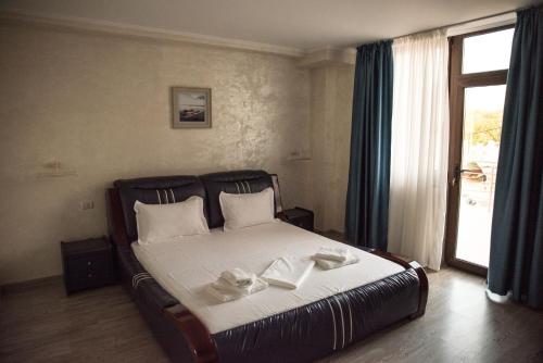 图尔恰La Marcu Pensiune的一间卧室配有一张床,上面有两条毛巾