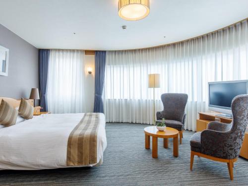 冈山冈山后乐酒店的配有一张床和一台平面电视的酒店客房