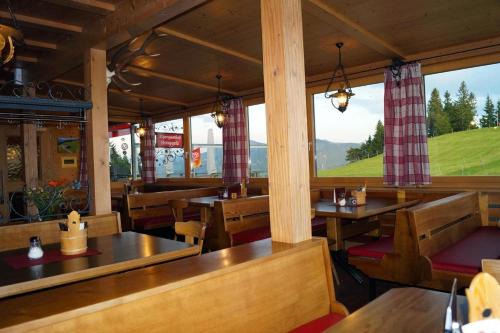 阿尔贝施文德阿尔卑斯布鲁格勒酒店的餐厅设有木桌、长凳和窗户。