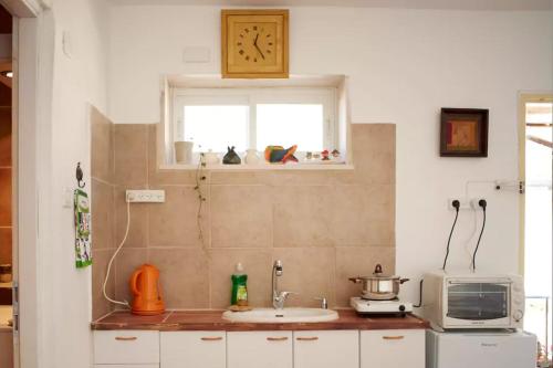 内韦伊兰Irit's Apartment的厨房配有水槽、微波炉和窗户