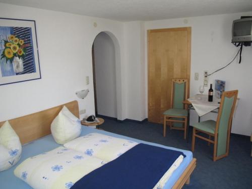 卡普尔奥斯利奥旅馆的卧室配有一张床和一张桌子及椅子