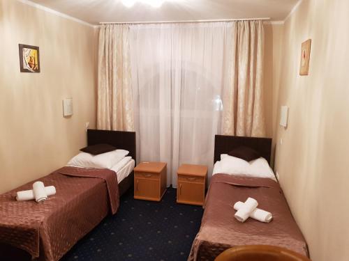 华沙Hotel Roko的酒店客房设有两张床和窗户。