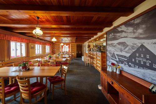 派克波特斯耐兹库孜孜科瓦布达霍斯基酒店的餐厅设有木桌、椅子和大屏幕