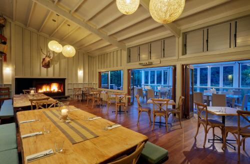 Awa-iti阿瓦罗瓦度假村的一间带桌椅和壁炉的用餐室
