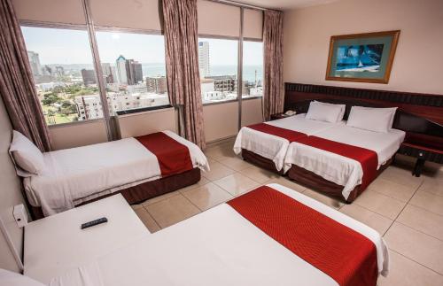 德班Coastlands Durban Self Catering Holiday Apartments的酒店客房设有两张床和窗户。
