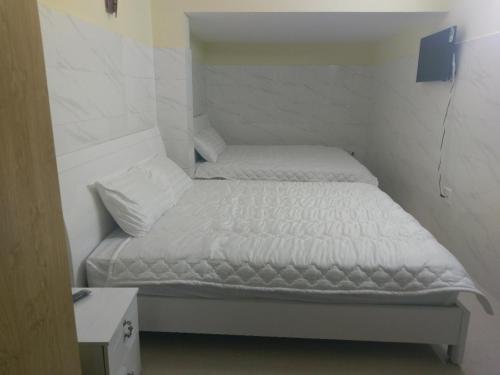 大叻ST.东潭宾馆的一间小卧室,配有白色床单