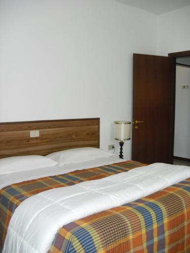 洛韦雷格拉兹拉度假屋的一间卧室配有一张带条纹毯子的大床