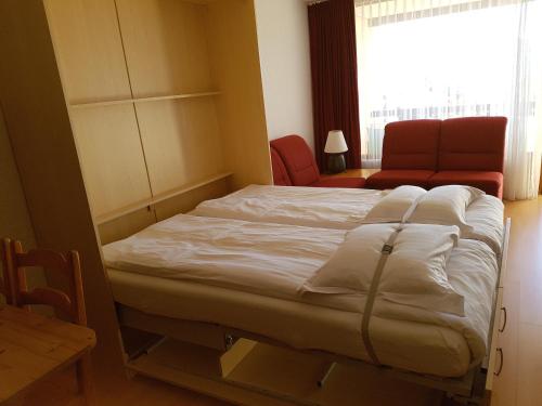 威拉尔-苏-罗伦Résidence Panorama A201的卧室配有床、椅子和窗户。