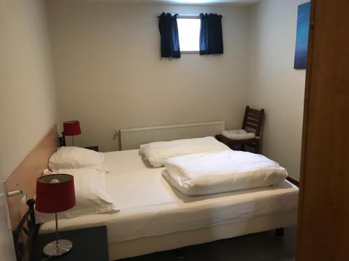 Goedereedede Goede Ree Huisje 1 en 2 - No Companies的一间卧室配有一张带白色床单的床和一扇窗户。