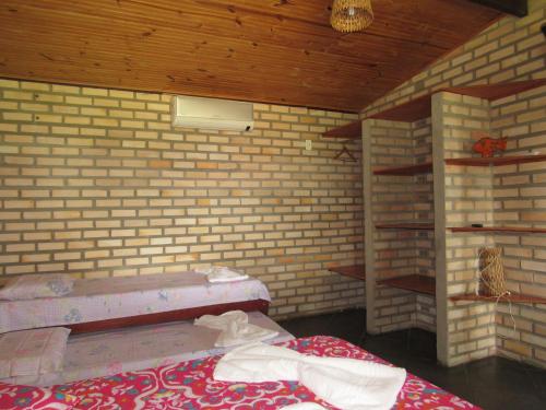 巴拉多库努Barravilha Chales的砖墙内带两张床的房间