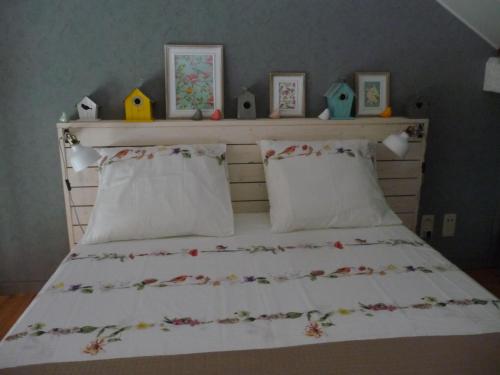 迪南Autrefois chez Lina的一间卧室配有一张铺有白色床单的床,床上有鸟儿