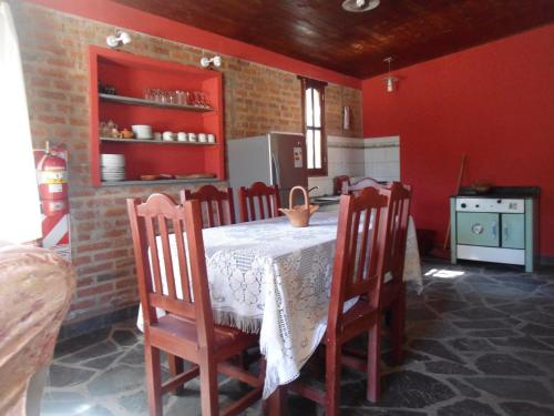 乌玛瓦卡El Churqui的厨房配有桌椅和红色墙壁。