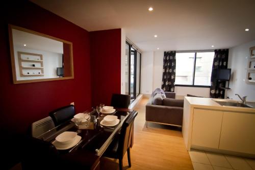 利物浦Merchant Quarters Apartments的一间带餐桌的客厅和一间厨房
