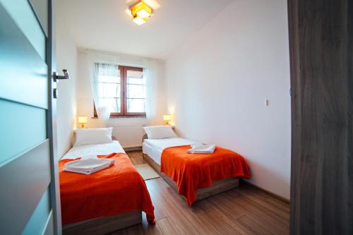 卡尔帕奇Apartament Mięta的小房间设有两张床和窗户