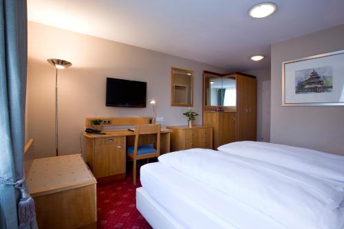 费尔巴赫科勒纳瑞兹酒店的酒店客房配有一张床和一张书桌及一台电视