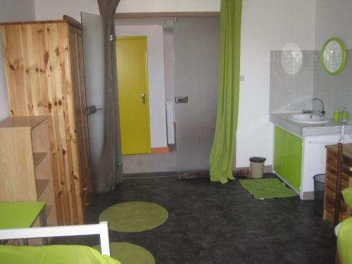 帕雷·勒·毛尼尔圣路易斯住宿加早餐旅馆的客房设有带水槽和绿色窗帘的浴室。