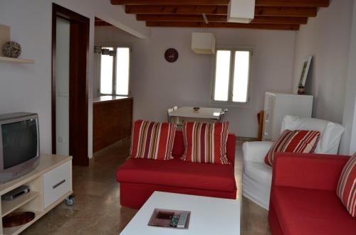 休达德亚Casa Fayas的客厅配有红色沙发和电视