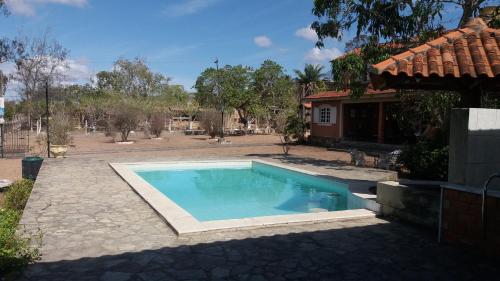 格拉瓦塔Casa de Campo com piscina的一座房子旁的院子内的游泳池