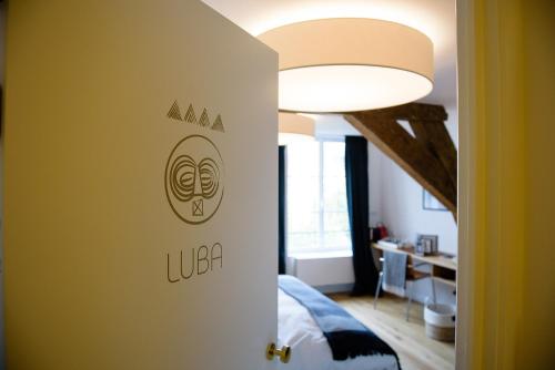 布鲁塞尔马丁客房酒店的一间房间,墙上有一张床和一盏灯