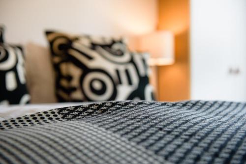 布鲁塞尔马丁客房酒店的一张带黑白枕头的床