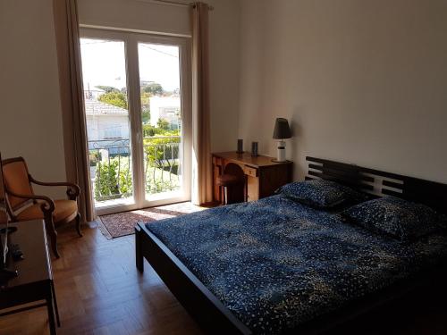 圣罗兰度瓦Villa Calliste的一间卧室配有一张床、一个窗口和一张书桌