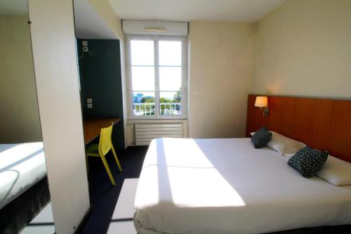 布雷斯特Hotel de la Gare Brest的卧室设有一张白色大床和一扇窗户。