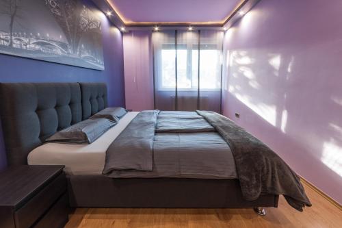 布达佩斯布达佩斯迷你风格公寓 - 你会爱上它！的紫色墙壁内的一张大床