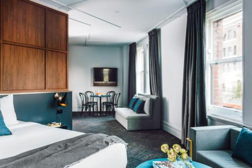 悉尼维如中心酒店的配有床、椅子和桌子的酒店客房