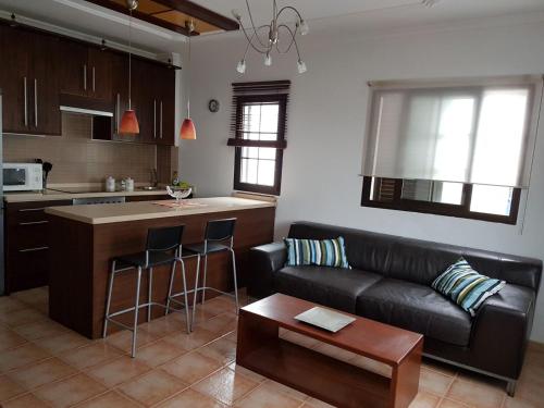 阿列塔Casa Garita Beach的一间带黑色沙发的客厅和一间厨房