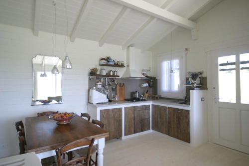 CanossaChalet Il Bosco dei Mille Frutti的厨房配有木桌和冰箱。