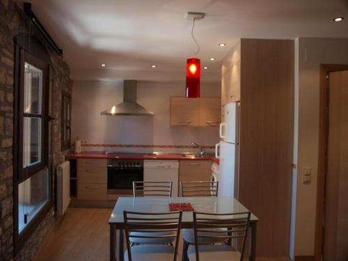 艾因萨El Mirador de Ainsa的厨房配有桌椅和冰箱。