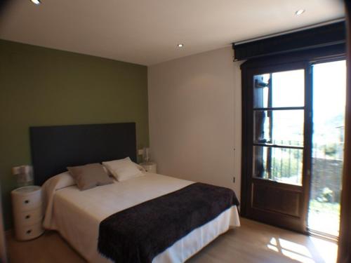 艾因萨El Mirador de Ainsa的一间卧室设有一张床和一个大窗户