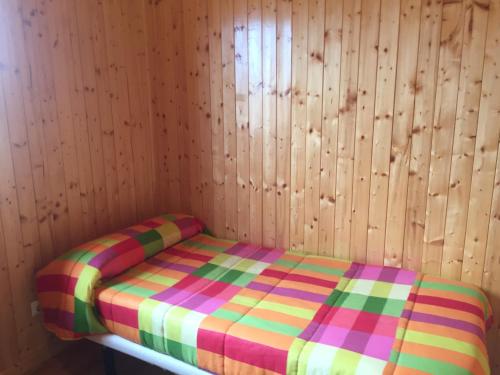 佩拉布若瓦Casa Rural Cuesta Grande的木墙客房的一张床位