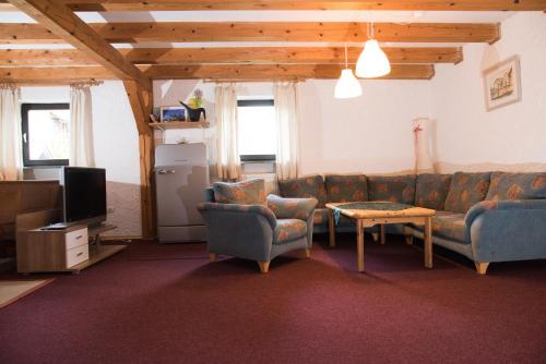 瓦尔德基兴Urlaub auf dem Weberhof的客厅配有沙发、椅子和电视