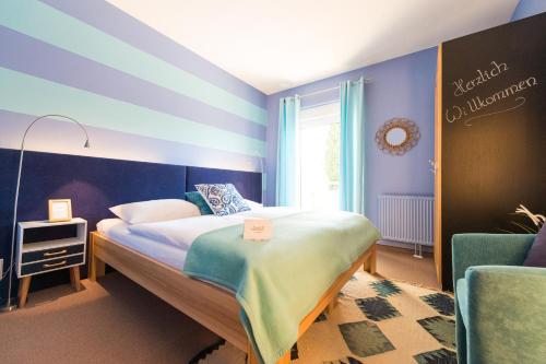 圣马丁安德达斯艾森伯格酒店的一间卧室配有一张蓝色和紫色墙壁的床