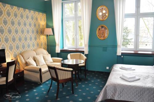 帕比亚尼采印象别墅酒店及餐厅的酒店客房配有床、沙发和桌子。