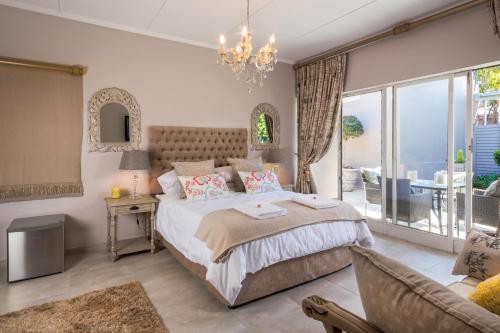 比勒陀利亚La Vida Luka - Luxury Guesthouse的一间带大床的卧室和一间客厅