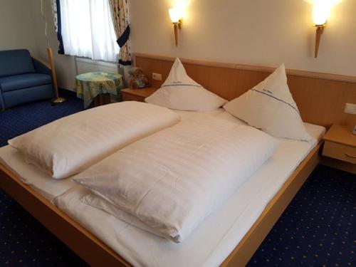WeißdorfGasthof Pension Walther的一张配有白色床单和枕头的大床