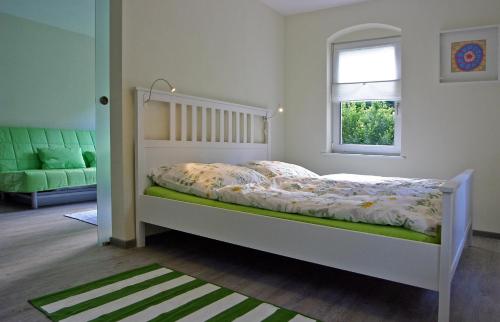 德累斯顿Kleines Häuschen - Ferien in Cossebaude的卧室配有白色的床和窗户。