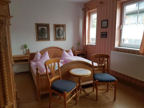 SpechtsbrunnGasthaus und Hotel Peterhänsel的一间卧室配有一张带桌椅的床