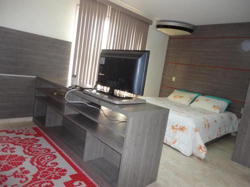 马瑙斯Flat Privado Manaus的一间卧室配有一张桌子,里面配有电视
