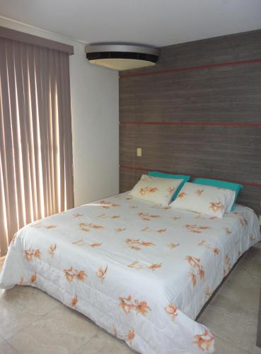 马瑙斯Flat Privado Manaus的一间卧室配有一张白色大床,床上有鲜花