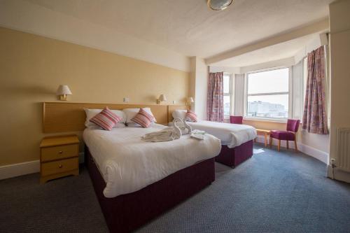 桑当星海酒店的酒店客房设有两张床和窗户。