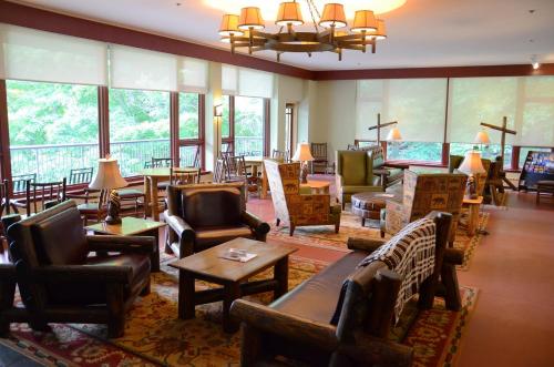 Highland FallsOverlook Lodge and Stone Cottages at Bear Mountain的酒店大堂设有桌椅和窗户。