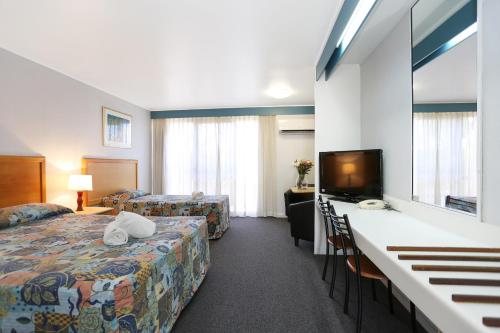 麦凯礁石度假汽车旅馆的配有一张床和一台平面电视的酒店客房