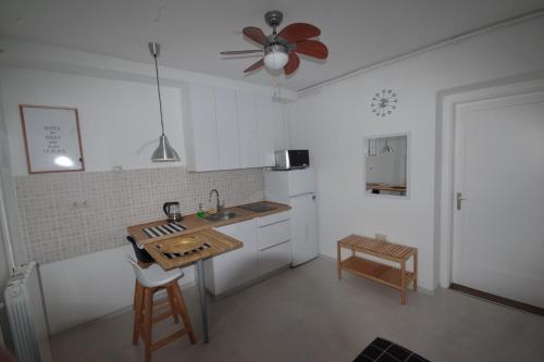 萨格勒布Jazzy Apartment Zagreb的厨房配有白色橱柜和吊扇