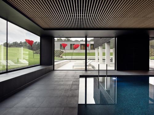 拉纳肯La Butte aux Bois的客房设有游泳池和大型玻璃窗。