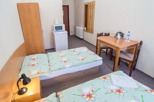 帕尔杜比采赫卡酒店的客房设有两张床、一张桌子和一张书桌。